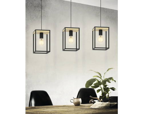 Drei Pendelleuchten mit kubischen Lampenschirmen aus Metall und Holzelementen über einem Esstisch.