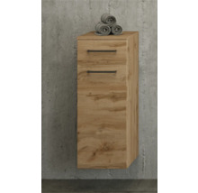 Wandhängender Badezimmerschrank in Eichenoptik mit einer Schublade, einer Tür und schwarzen Griffen vor einer Betonwand.