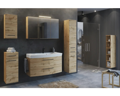 Badezimmer-Set in Eiche-Optik mit Waschtisch, Spiegelschrank inklusive Beleuchtung und mehreren Schränken in einem modern gestalteten Badezimmer.