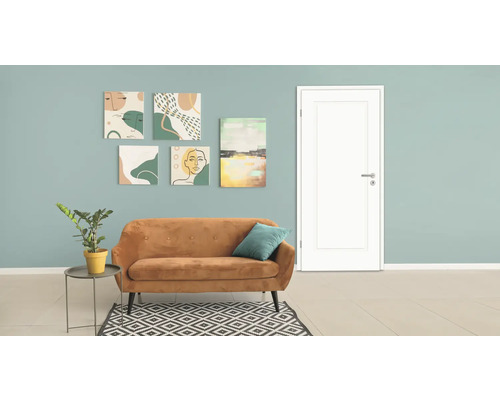 Salon avec canapé, plante d'intérieur, tapis et œuvres d'art au mur