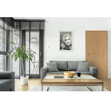 Wohnzimmer mit Sofa, Tisch, Zimmerpflanze und Bild