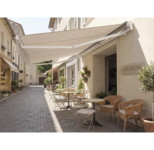 Aussenbereich eines Cafés mit Markise und Sitzgelegenheiten auf einer gepflasterten Strasse