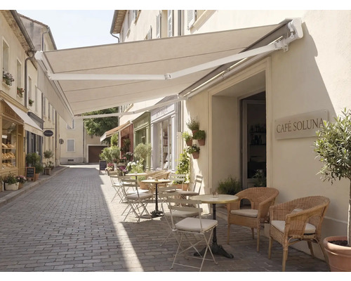 Aussenbereich eines Cafés mit Markise und Sitzgelegenheiten auf einer gepflasterten Strasse