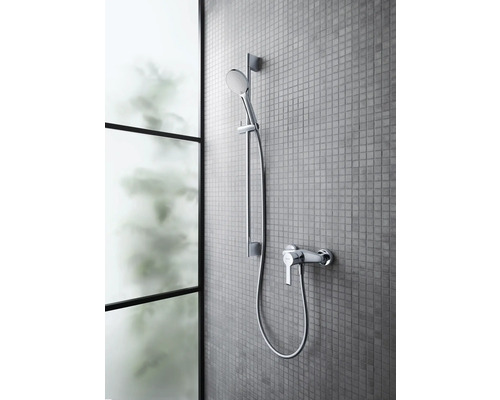 Robinet de douche avec douchette sur un mur carrelé