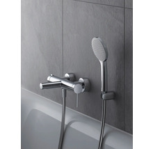 Aufputz-Badarmatur mit Handbrause an einer grauen Wand über einer Badewanne