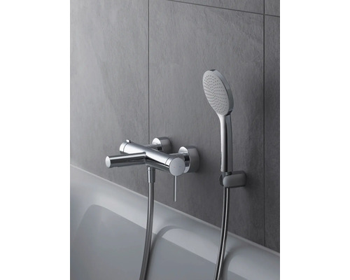 Aufputz-Badarmatur mit Handbrause an einer grauen Wand über einer Badewanne