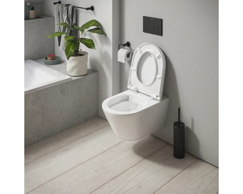 Wandhängendes WC mit offenem Spülrand und Toilettenbürste im Badezimmer.