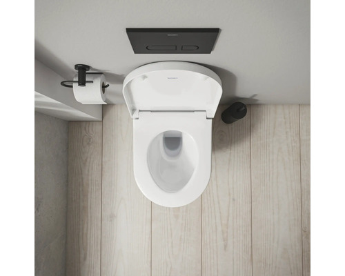 Aufnahme von oben einer Toilette mit offenem Deckel, Spültaste und Toilettenpapierhalter