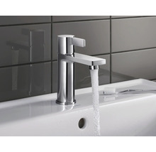 Wasserhahn aus Chrom auf einem Waschbecken mit fließendem Wasser.