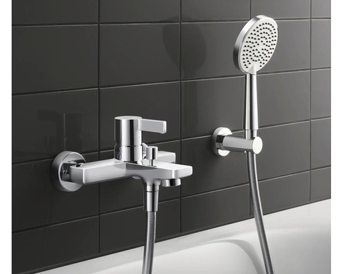 Aufputz-Badewannenarmatur mit Handbrause vor dunklem Fliesenspiegel