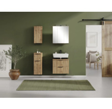 Modernes Badezimmer Set mit Waschtischunterschrank und Wandschränken in Holzoptik mit Lamellenstruktur vor einer grünen Wand.