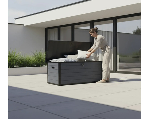 Frau verstaut Kissen in einer grauen Gartenbox im Außenbereich