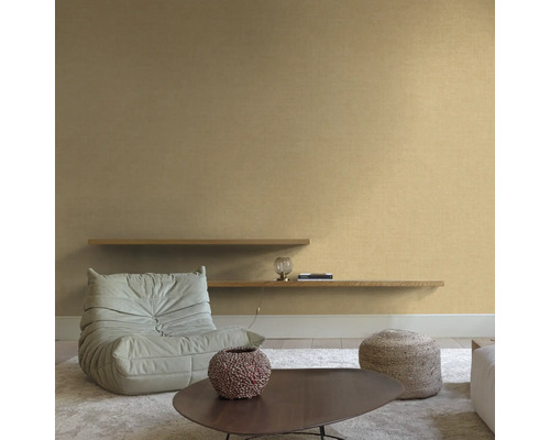 Wohnzimmer mit Sessel, Couchtisch und Regalen an der Wand.