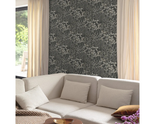 Wohnzimmer mit floral gemusterter Tapete und einem Sofa