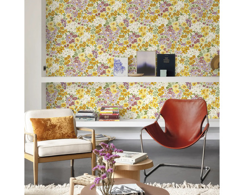 Salon avec papier peint floral, étagères et fauteuils