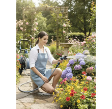 Femme arrosant des fleurs avec un pistolet d'arrosage dans un jardin fleuri.