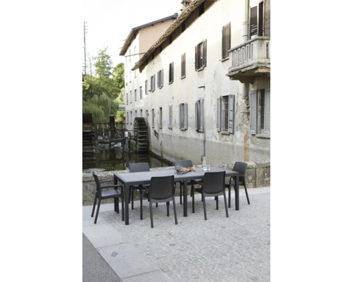 Ensemble de meubles de jardin avec table et chaises devant un décor historique
