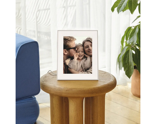 Cadre photo numérique sur une table d appoint ronde en bois dans le salon, affichant une photo de famille