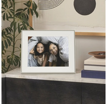 Cadre photo sobre avec passe-partout posé sur une commode, montrant une photo de deux enfants.