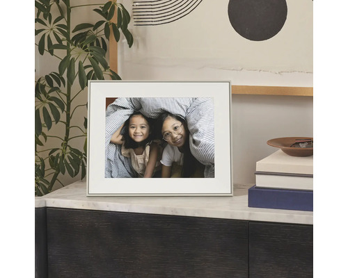 Cadre photo sobre avec passe-partout posé sur une commode, montrant une photo de deux enfants.