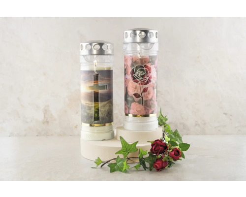 Zwei Grablichter mit christlichen Motiven, inklusive Kreuz und Rosenmuster