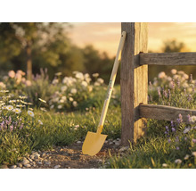 Scène de jardin avec bêche contre une clôture en bois