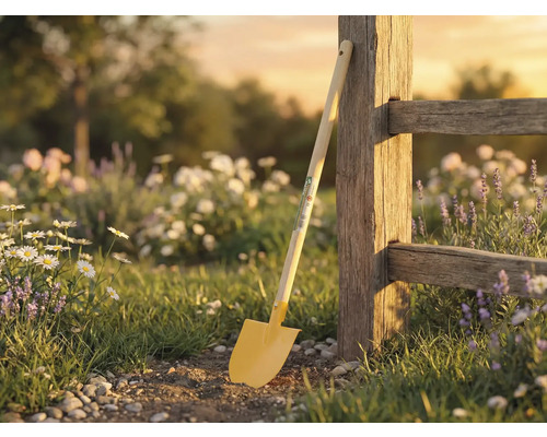 Scène de jardin avec bêche contre une clôture en bois