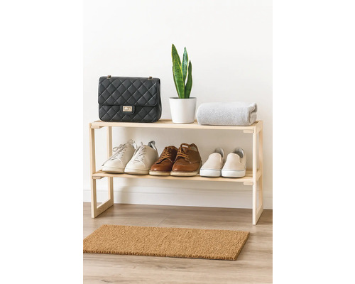 Étagère à chaussures en bois avec chaussures, sac à main, plante et couverture