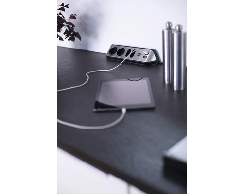 Bloc multiprise avec ports USB et tablette connectée sur une table