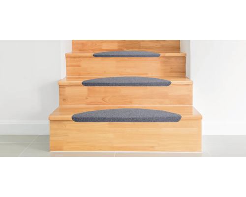 Holztreppe mit grauen Stufenmatten.