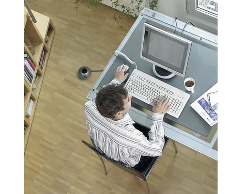 Blick von oben auf eine Person, die an einem Schreibtisch mit Computer, Tastatur und Maus arbeitet.