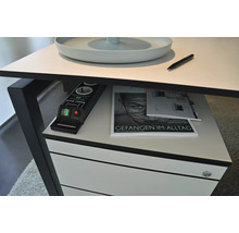 Vue détaillée d'un bureau avec multiprise, magazines et stylo