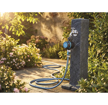 Scène de jardin avec robinet, programmateur d'arrosage et tuyau d'arrosage