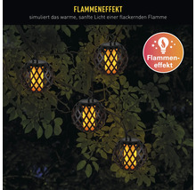 Plusieurs lampes de jardin suspendues avec effet de flamme entre les branches