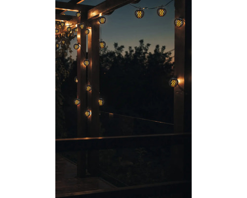 Guirlande lumineuse décorative avec des lampes sphériques sur une pergola en bois