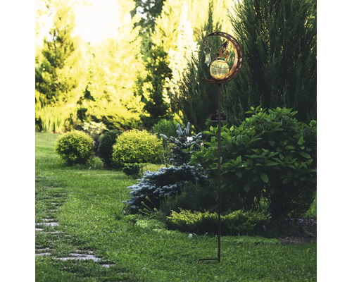 Gartenansicht mit einer Solarleuchte mit Monddesign auf einem Rasen