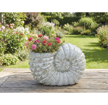 Pflanzgefäß in Form einer Schnecke mit blühenden Blumen auf einem Holztisch im Garten