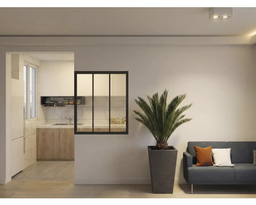 Salon avec plante, canapé et passage vers la cuisine