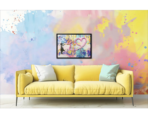 Canapé jaune avec coussins devant un mur avec une image encadrée d'une fille et d'un cœur