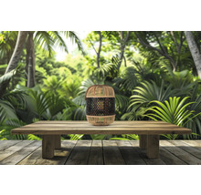 Lanterne décorative en bambou sur une table en bois devant une jungle en arrière-plan