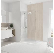 Salle de bains lumineuse avec paroi de douche, lavabo et tapis de bain