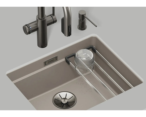 Évier avec robinet, distributeur de savon et égouttoir dans l'évier