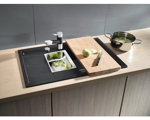 Évier de cuisine avec égouttoir, robinet, planche à découper et casserole