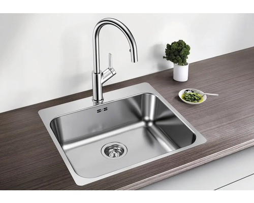 Évier en acier inoxydable avec robinet sur un plan de travail