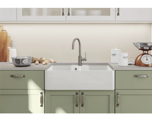 Küchenszene mit Spüle, Armatur und Küchenutensilien auf einer Arbeitsplatte