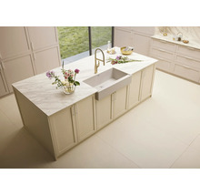 Îlot de cuisine avec évier, robinetterie et plateau en marbre dans une pièce lumineuse