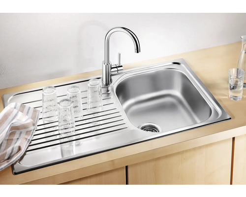 Évier en acier inoxydable avec égouttoir et robinet, avec des verres dessus pour sécher