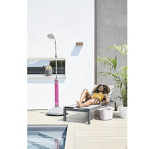 Scène avec une femme sur une chaise longue à côté d'une douche de jardin et d'une piscine