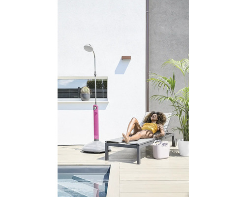 Scène avec une femme sur une chaise longue à côté d'une douche de jardin et d'une piscine