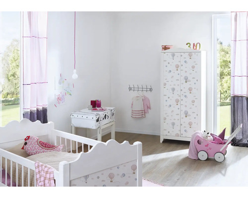 Chambre d'enfant avec lit à barreaux, armoire et chariot à jouets.
